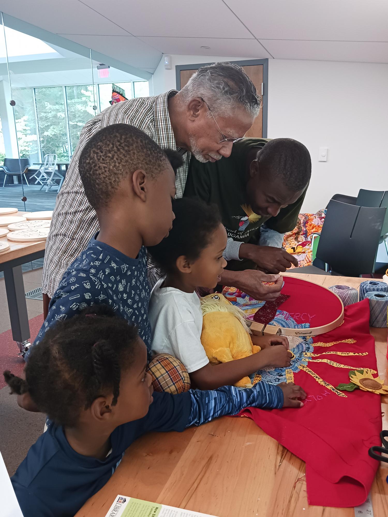 "Sunshine Joe" Mallard teaches quilting to a family