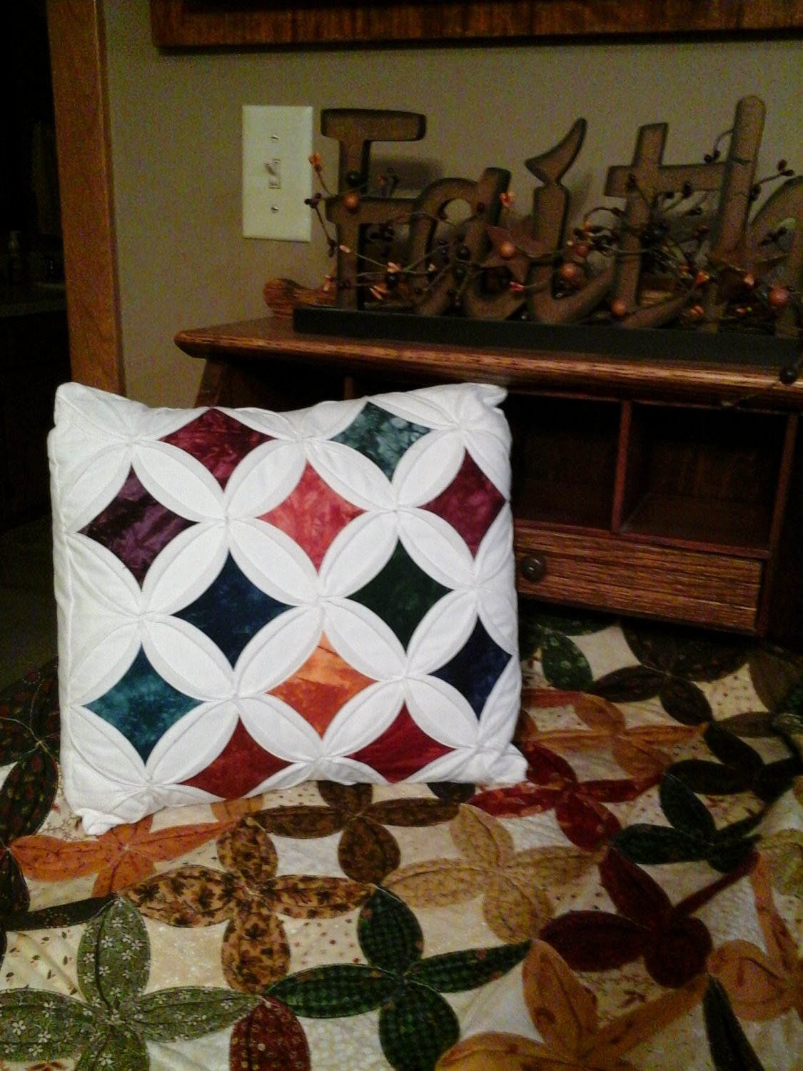 Pillow featuring a Cathedral Windows pattern.