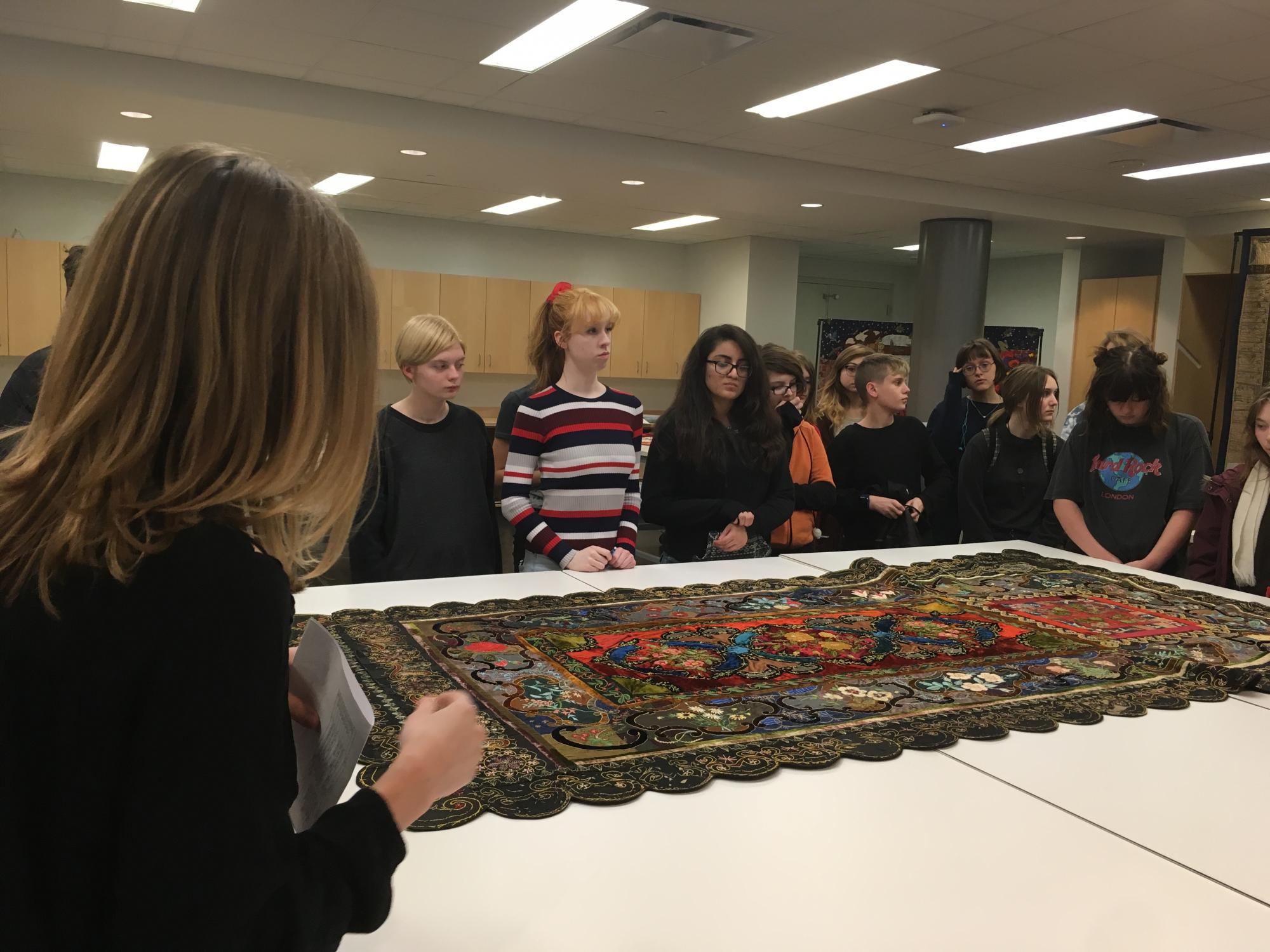 LPS Arts & Humanities students view a quilted coffin cover during the 2017 pop-up exhibit "The Haunting of Quilt House."