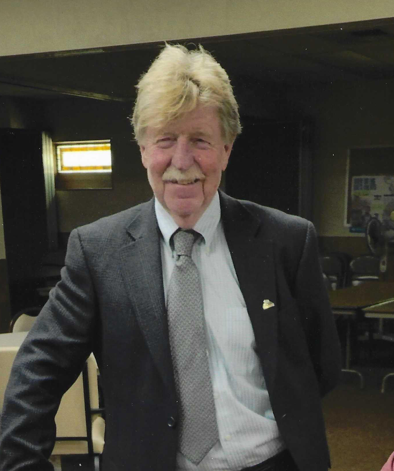Richard Boston poses for a photo wearing a suit.