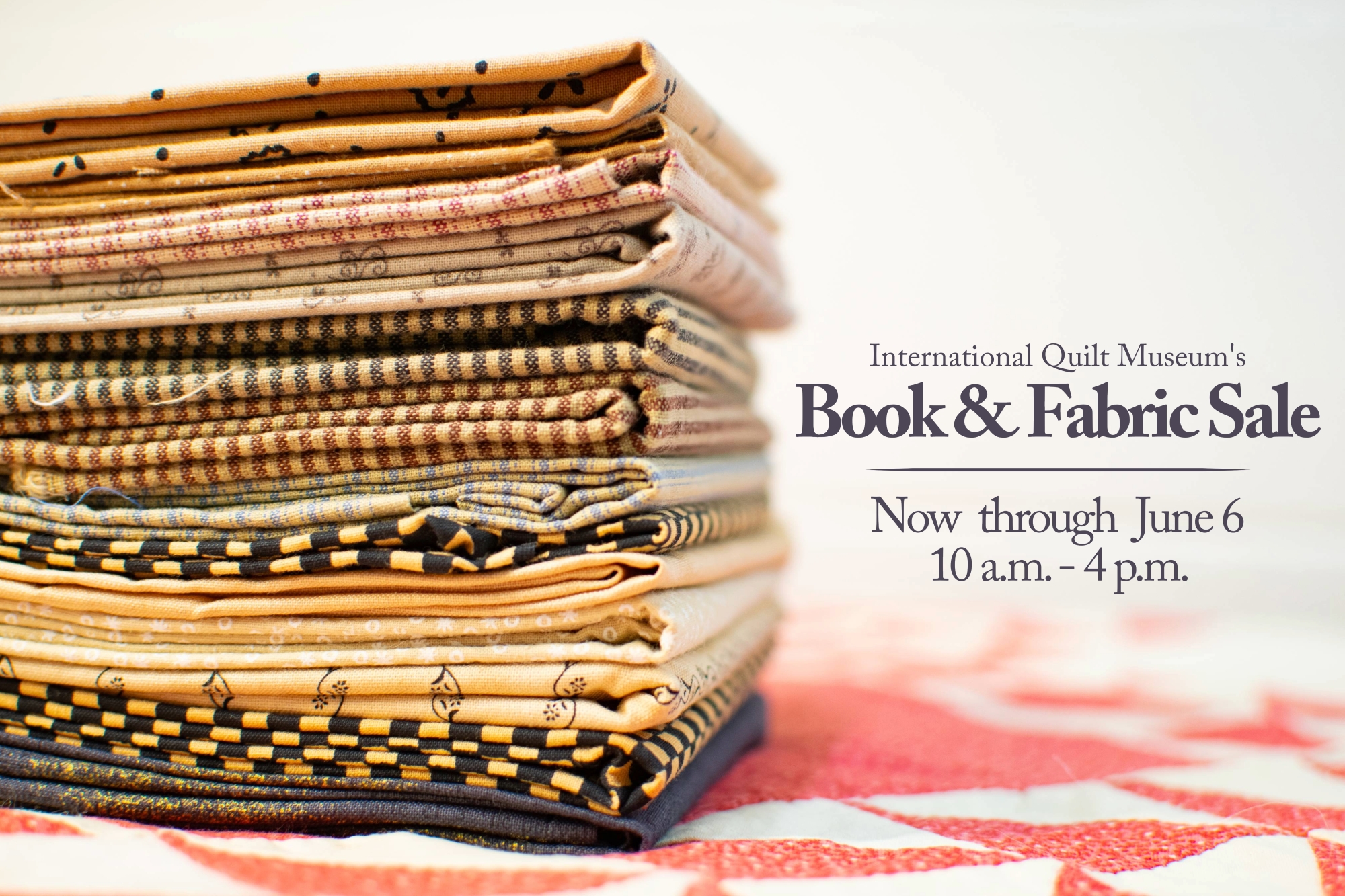 Fabric swatches stacked on a red and white quilt top