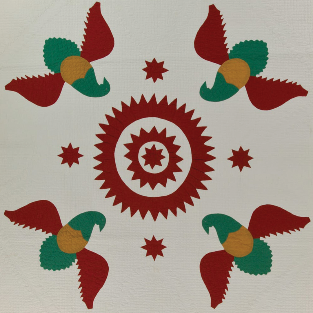 Quilt photo showing birds surrounding a red circle. 