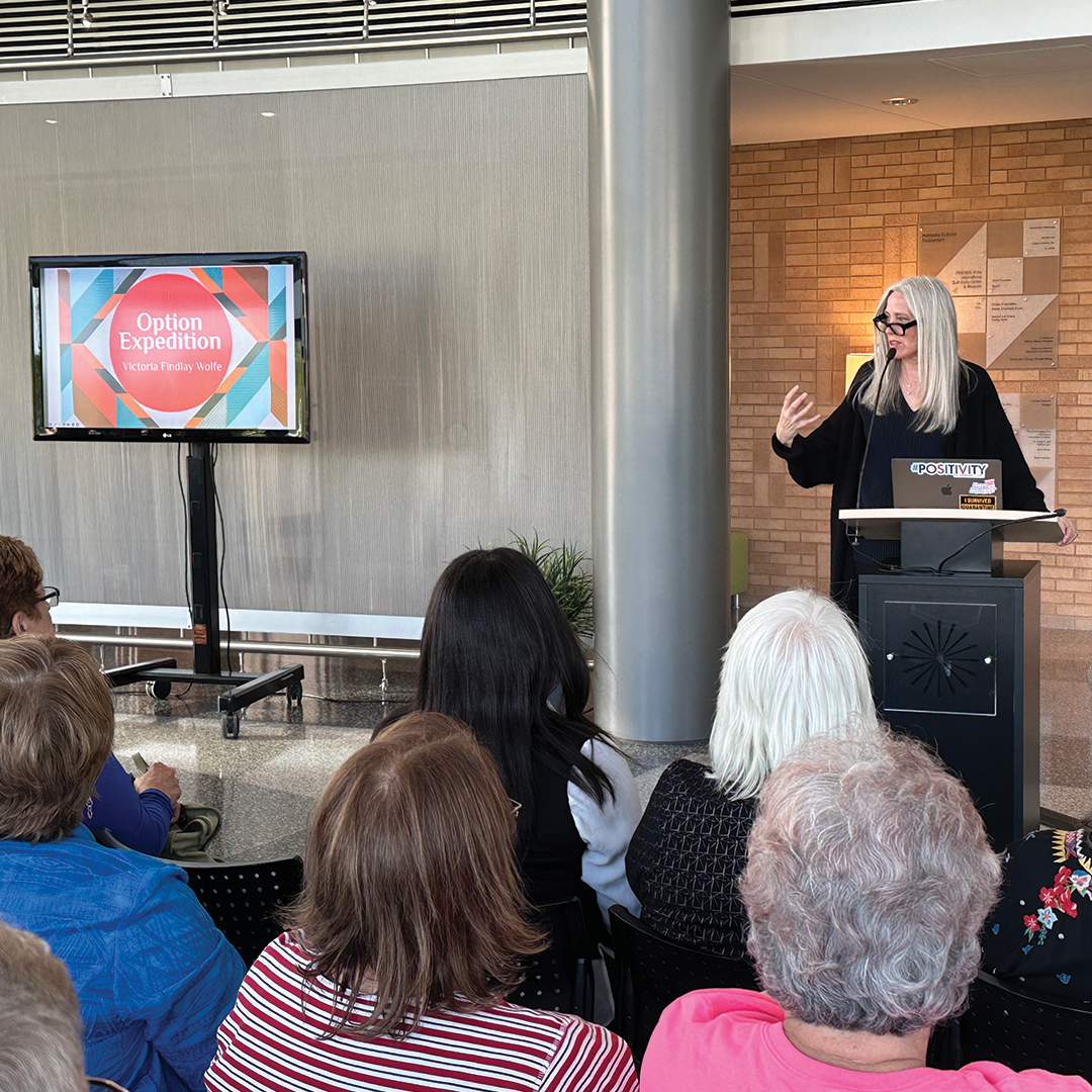 Photo of Victoria Findlay Wolfe giving a presentation to guests at the IQM. 