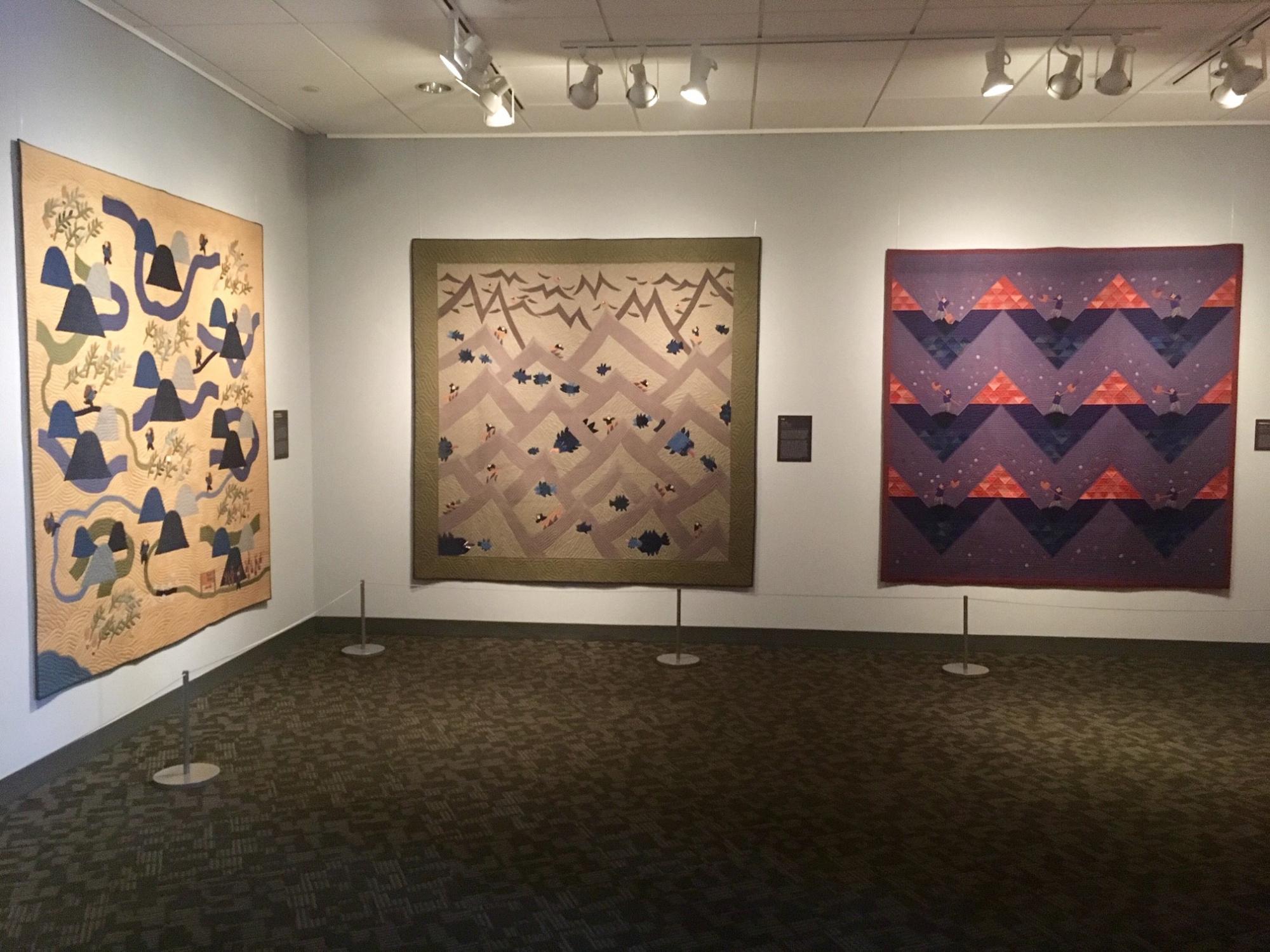 Three Rumi O'Brien quilts on display in a gallery.