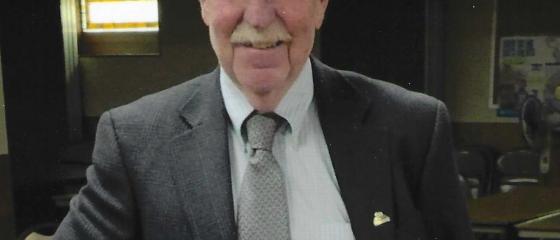 Richard Boston poses for a photo wearing a suit. 