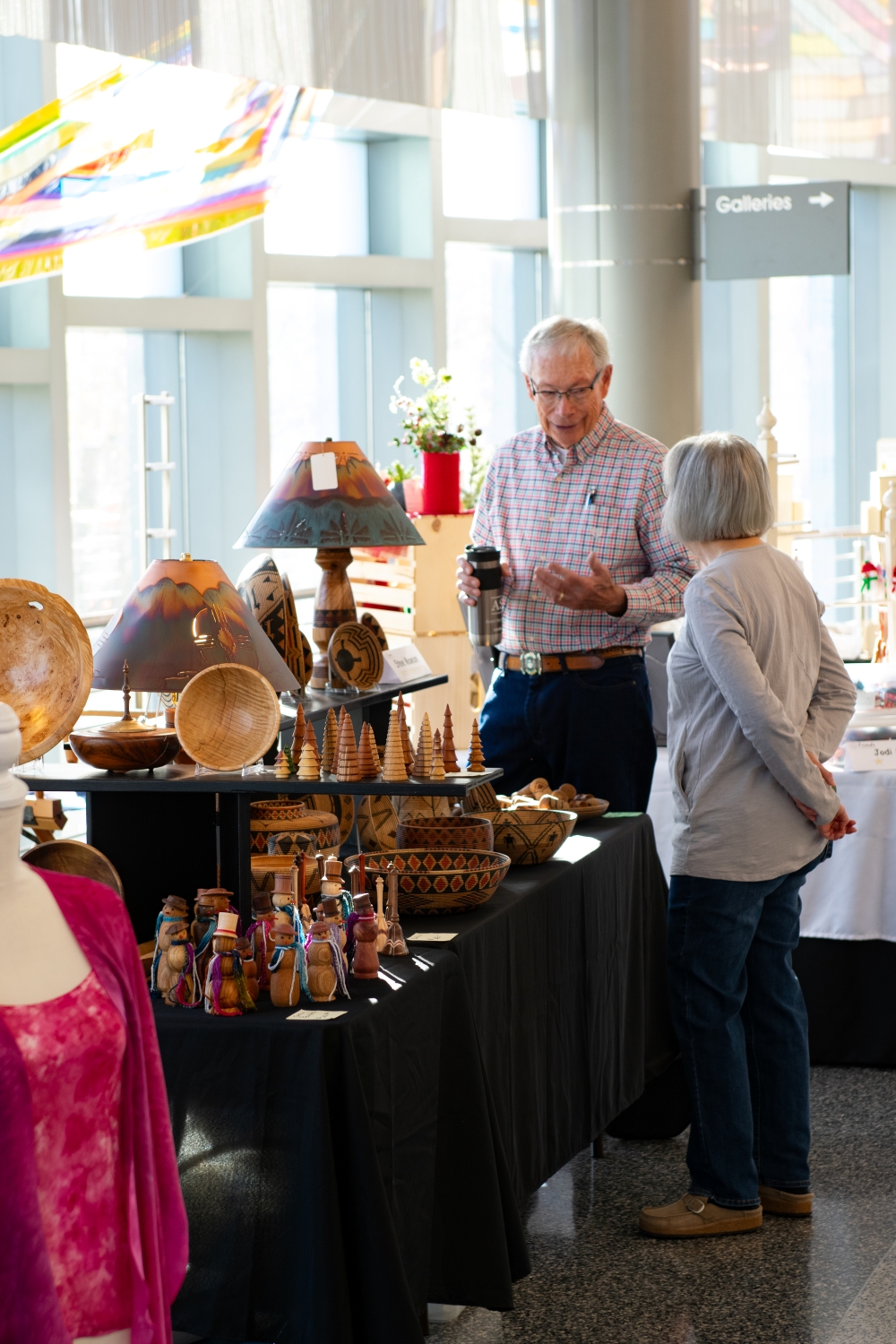 Two people speaking at art market.
